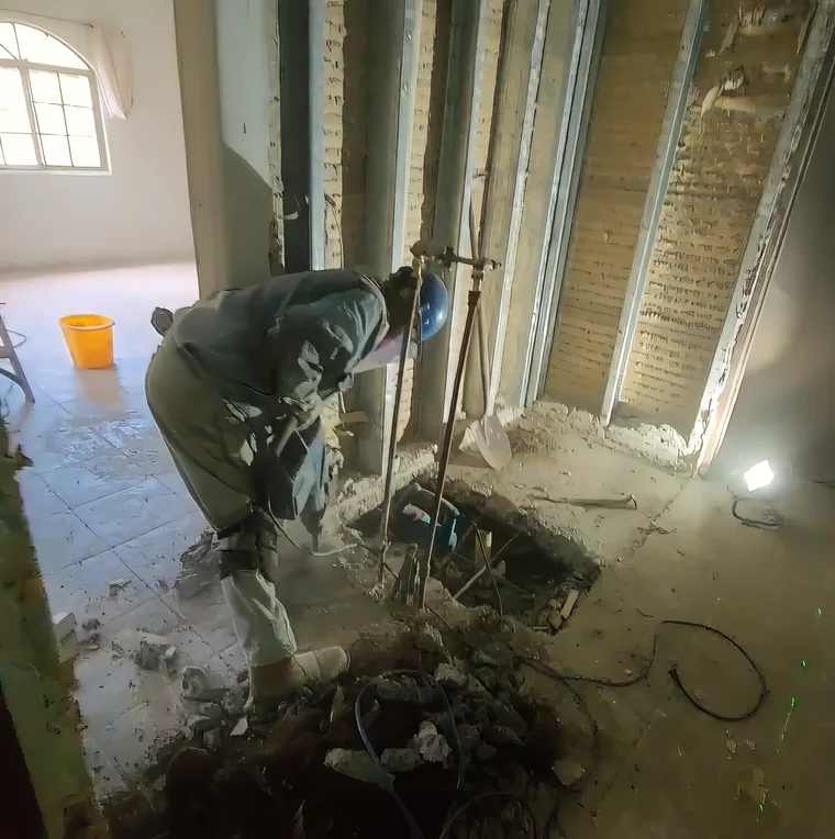Person reviewing exposed structural work inside a renovation site